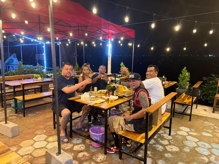 Friends raising their glasses around a table full of dishes on the terrace